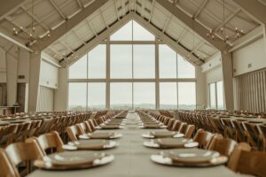 A wedding venue's dining room with set tables and a large open window